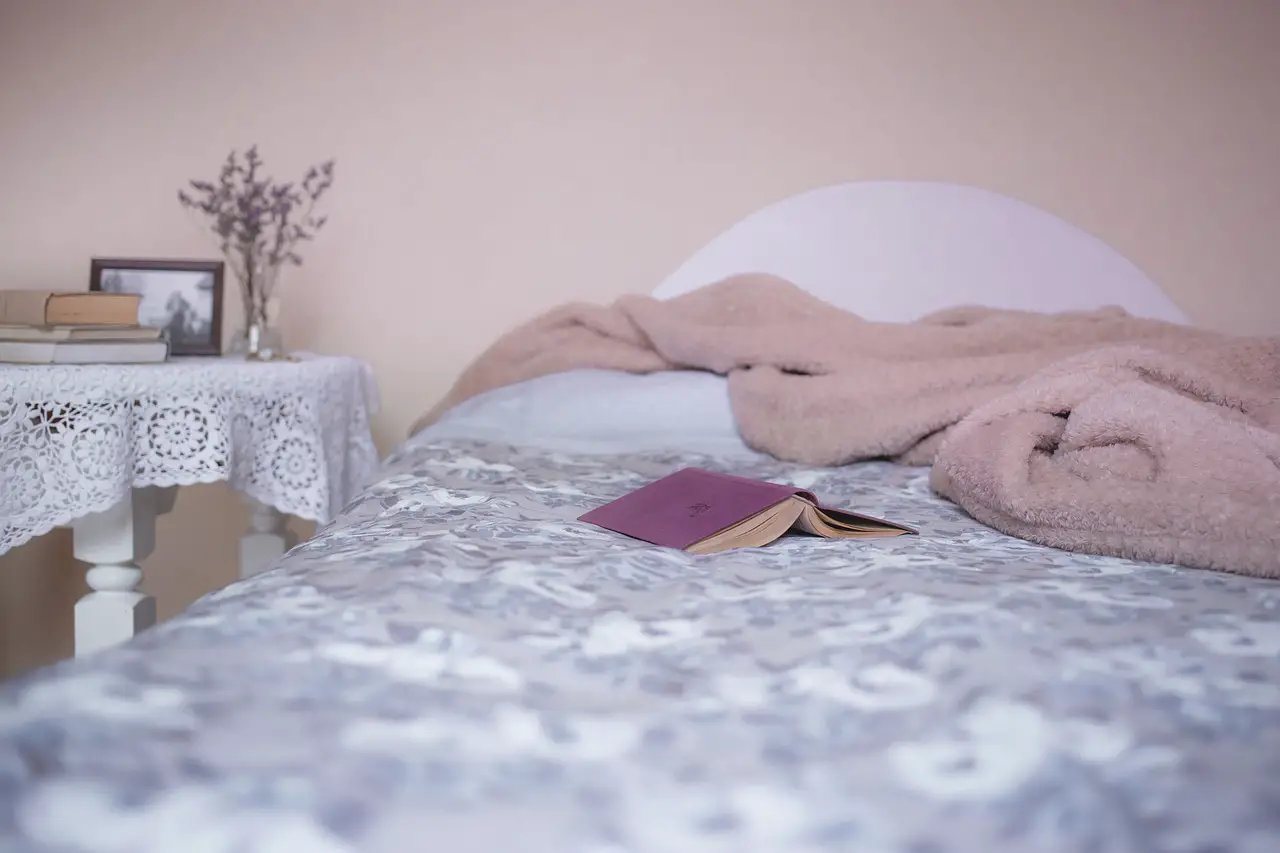 bed with a book flipped over