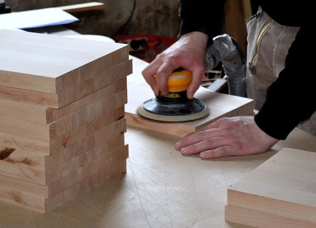 A carpenter working on pieces of wood on  workbench